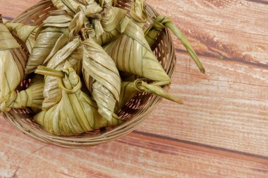 Ketupat (pirinç hamur tatlısı) ahşap arka plan üzerinde. Genç Hindistan cevizi yapılan bir doğal pirinç kaplama pirinç eid Mubarak sırasında yemek pişirmek için yaprakları Ketupat olduğunu