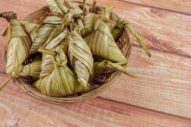 Ketupat (pirinç hamur tatlısı) ahşap arka plan üzerinde. Genç Hindistan cevizi yapılan bir doğal pirinç kaplama pirinç eid Mubarak sırasında yemek pişirmek için yaprakları Ketupat olduğunu