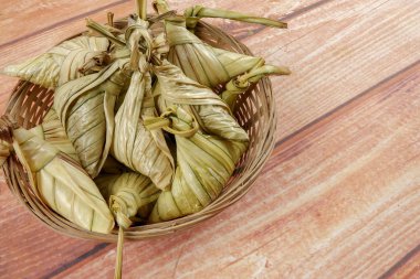 Ketupat (pirinç hamur tatlısı) ahşap arka plan üzerinde. Genç Hindistan cevizi yapılan bir doğal pirinç kaplama pirinç eid Mubarak sırasında yemek pişirmek için yaprakları Ketupat olduğunu