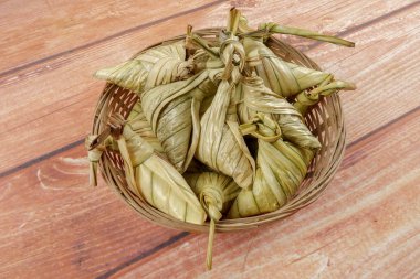 Ketupat (pirinç hamur tatlısı) ahşap arka plan üzerinde. Genç Hindistan cevizi yapılan bir doğal pirinç kaplama pirinç eid Mubarak sırasında yemek pişirmek için yaprakları Ketupat olduğunu