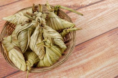 Ketupat (pirinç hamur tatlısı) ahşap arka plan üzerinde. Genç Hindistan cevizi yapılan bir doğal pirinç kaplama pirinç eid Mubarak sırasında yemek pişirmek için yaprakları Ketupat olduğunu