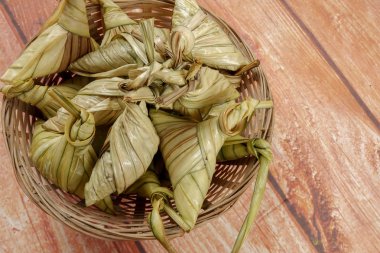Ketupat (pirinç hamur tatlısı) ahşap arka plan üzerinde. Genç Hindistan cevizi yapılan bir doğal pirinç kaplama pirinç eid Mubarak sırasında yemek pişirmek için yaprakları Ketupat olduğunu