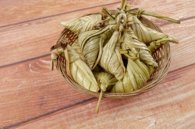 Ketupat (pirinç hamur tatlısı) ahşap arka plan üzerinde. Genç Hindistan cevizi yapılan bir doğal pirinç kaplama pirinç eid Mubarak sırasında yemek pişirmek için yaprakları Ketupat olduğunu