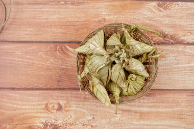 Ketupat (pirinç hamur tatlısı) ahşap arka plan üzerinde. Genç Hindistan cevizi yapılan bir doğal pirinç kaplama pirinç eid Mubarak sırasında yemek pişirmek için yaprakları Ketupat olduğunu