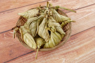 Ketupat (pirinç hamur tatlısı) ahşap arka plan üzerinde. Genç Hindistan cevizi yapılan bir doğal pirinç kaplama pirinç eid Mubarak sırasında yemek pişirmek için yaprakları Ketupat olduğunu