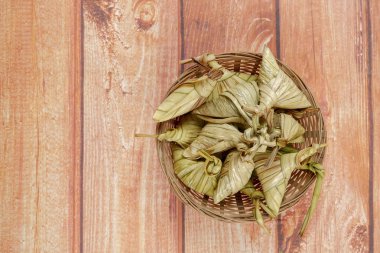 Ketupat (pirinç hamur tatlısı) ahşap arka plan üzerinde. Genç Hindistan cevizi yapılan bir doğal pirinç kaplama pirinç eid Mubarak sırasında yemek pişirmek için yaprakları Ketupat olduğunu