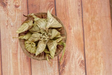 Ketupat (pirinç hamur tatlısı) ahşap arka plan üzerinde. Genç Hindistan cevizi yapılan bir doğal pirinç kaplama pirinç eid Mubarak sırasında yemek pişirmek için yaprakları Ketupat olduğunu