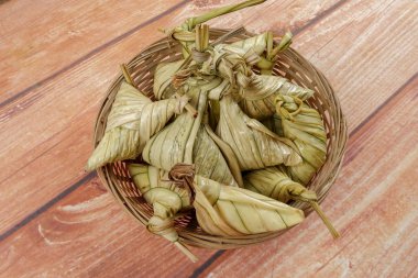 Ketupat (pirinç hamur tatlısı) ahşap arka plan üzerinde. Genç Hindistan cevizi yapılan bir doğal pirinç kaplama pirinç eid Mubarak sırasında yemek pişirmek için yaprakları Ketupat olduğunu