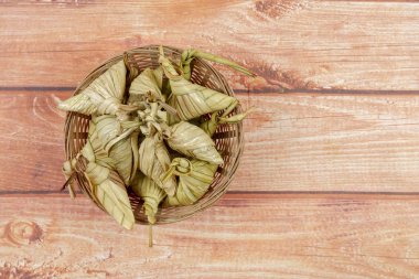 Ketupat (pirinç hamur tatlısı) ahşap arka plan üzerinde. Genç Hindistan cevizi yapılan bir doğal pirinç kaplama pirinç eid Mubarak sırasında yemek pişirmek için yaprakları Ketupat olduğunu