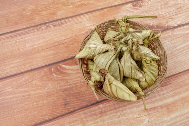 Ketupat (pirinç hamur tatlısı) ahşap arka plan üzerinde. Genç Hindistan cevizi yapılan bir doğal pirinç kaplama pirinç eid Mubarak sırasında yemek pişirmek için yaprakları Ketupat olduğunu