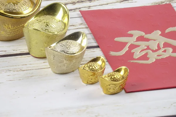 在木制背景下 农历新年的黄金锭和红钱包 汉字意味着运气 财富和繁荣 如图所示 — 图库照片