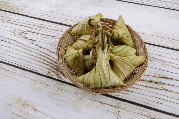 Ketupat (pirinç hamur tatlısı) ahşap arka plan üzerinde. Genç Hindistan cevizi yapılan bir doğal pirinç kaplama pirinç eid Mubarak sırasında yemek pişirmek için yaprakları Ketupat olduğunu