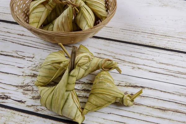 Ketupat (Rice Dumpling) On wooden Background. Ketupat is a natural rice casing made from young coconut leaves for cooking rice during eid Mubarak