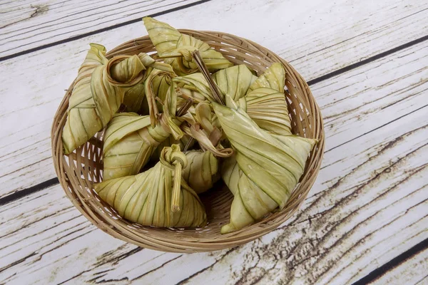 Ketupat (pirinç hamur tatlısı) ahşap arka plan üzerinde. Genç Hindistan cevizi yapılan bir doğal pirinç kaplama pirinç eid Mubarak sırasında yemek pişirmek için yaprakları Ketupat olduğunu