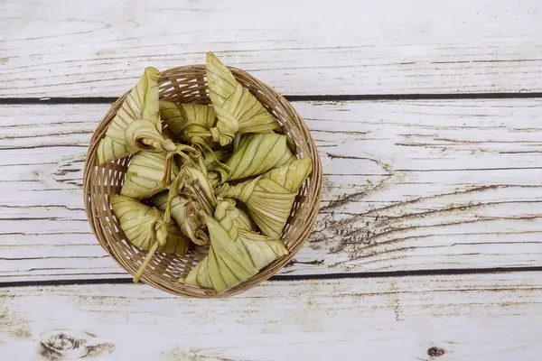 Ketupat (pirinç hamur tatlısı) ahşap arka plan üzerinde. Genç Hindistan cevizi yapılan bir doğal pirinç kaplama pirinç eid Mubarak sırasında yemek pişirmek için yaprakları Ketupat olduğunu