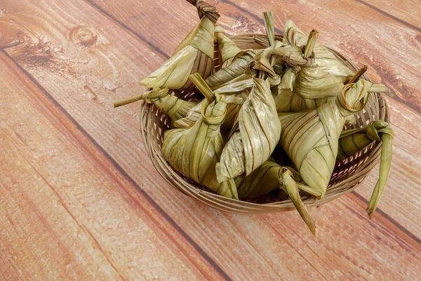 Ketupat (pirinç hamur tatlısı) ahşap arka plan üzerinde. Genç Hindistan cevizi yapılan bir doğal pirinç kaplama pirinç eid Mubarak sırasında yemek pişirmek için yaprakları Ketupat olduğunu