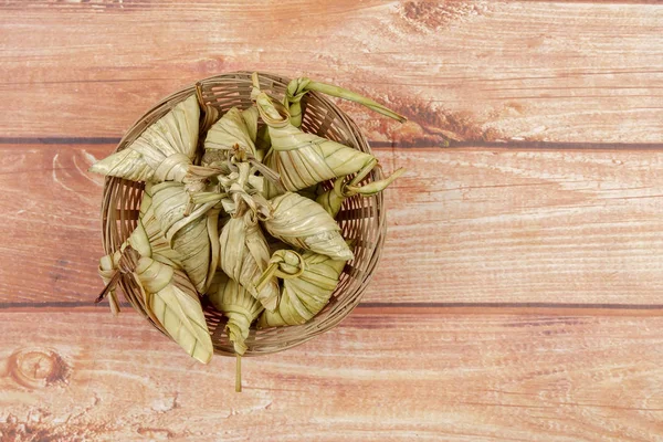 Ketupat (pirinç hamur tatlısı) ahşap arka plan üzerinde. Genç Hindistan cevizi yapılan bir doğal pirinç kaplama pirinç eid Mubarak sırasında yemek pişirmek için yaprakları Ketupat olduğunu