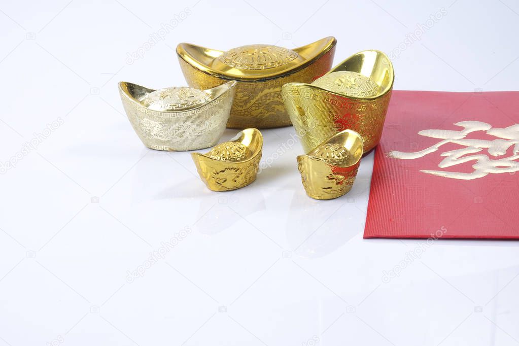 Chinese new year festival decorations, ang pow or red packet and gold ingots. Chinese characters means luck,wealth and prosperity.