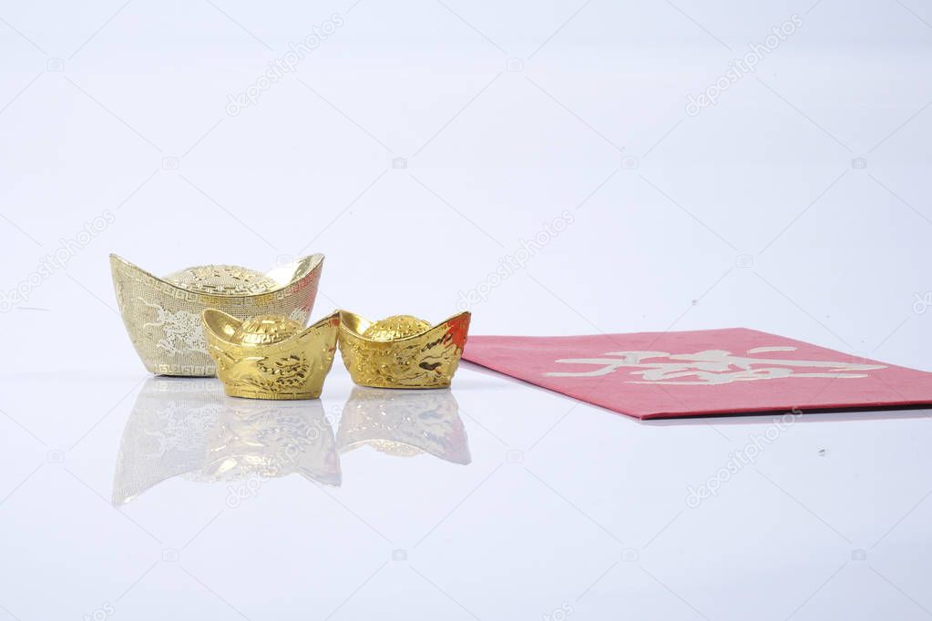 Chinese new year festival decorations, ang pow or red packet and gold ingots. Chinese characters means luck,wealth and prosperity.