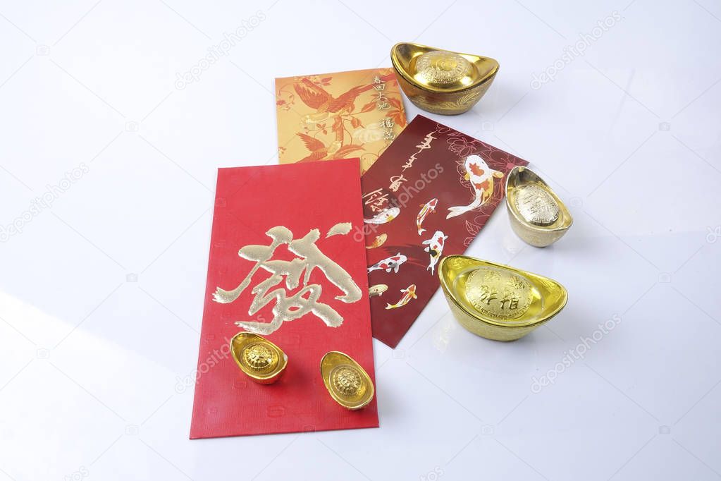 Chinese new year festival decorations, ang pow or red packet and gold ingots. Chinese characters means luck,wealth and prosperity.