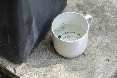 Stagnan çöp konteyner ve potansiyel musquitoes zemin ıslahı için plastik bardak suda. Bulanık resim.