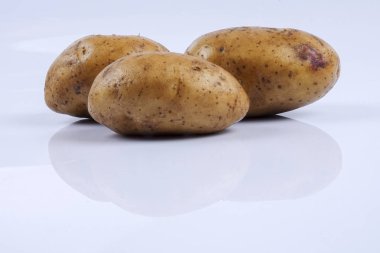 Beyaz arka planda taze çiğ patates.
