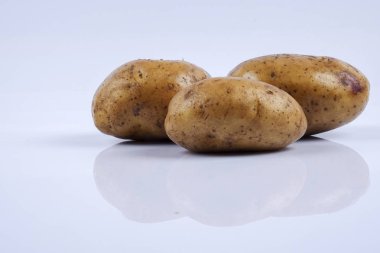 Beyaz arka planda taze çiğ patates.