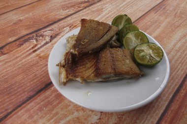 Ahşap arka plan üzerinde limonlu tuzlu balık.