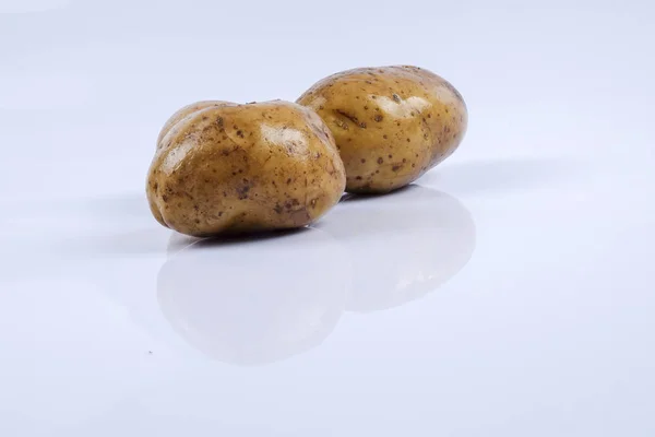 Färsk rå potatis på vit bakgrund. — Stockfoto