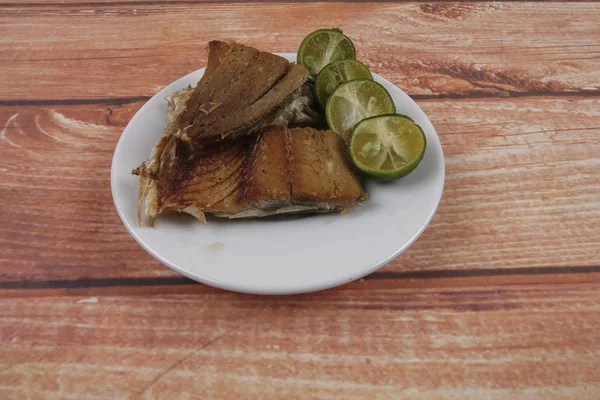Gezouten vis met kalk op houten achtergrond. — Stockfoto