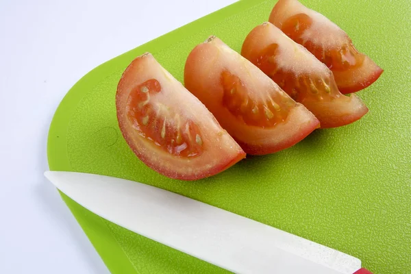 Tomatenscheiben auf grünem Schneidebrett. — Stockfoto