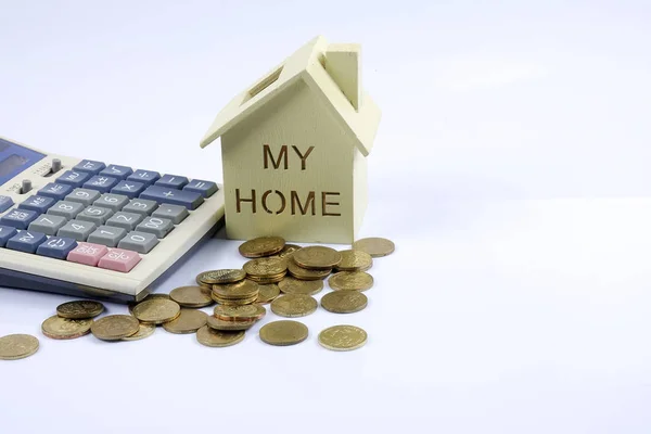 Houten huis model met stapel munt en calculator. — Stockfoto