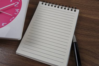 zaman yönetimi kavramsal, kitap, kalem ve ahşap saat