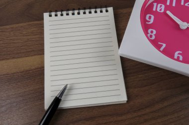 zaman yönetimi kavramsal, kitap, kalem ve ahşap saat