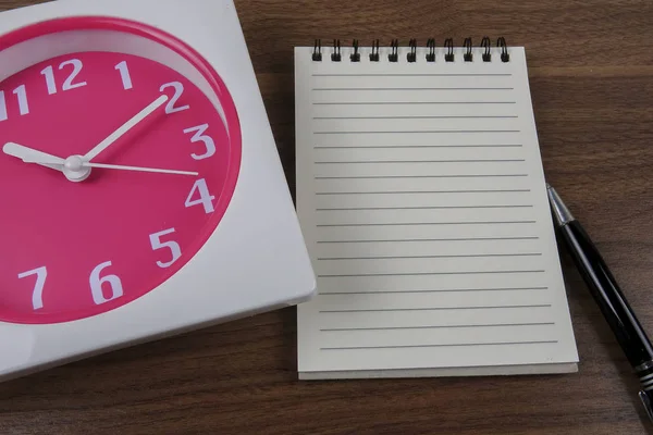 Ώρα διαχείριση εννοιολογική, βιβλίο, στυλό και το ρολόι στο ξύλο — Φωτογραφία Αρχείου