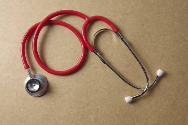 Ahşap arka plan üzerinde kırmızı stetoskop. Tıbbi ve sağlık kavramı.