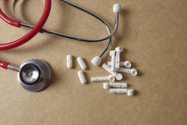 Stéthoscope rouge sur fond en bois. Concept médical et soins de santé . — Photo