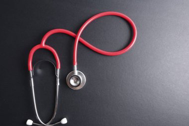 Kırmızı stetoskop, klavye, bulmaca ve para. Tıp kavramı.