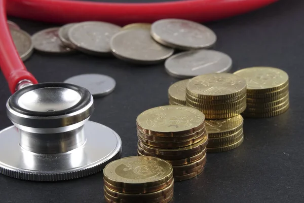 Red stethoscope,coin and puzzle on black. Medical concept. — Stock Photo, Image