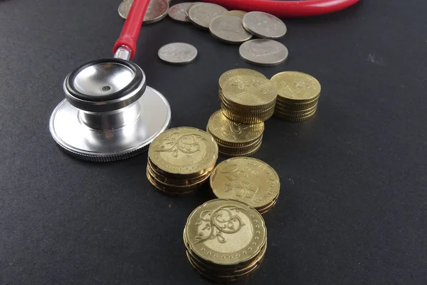 Czerwony stetoskop, monet i puzzle na czarny. Pojęcie medyczne. — Zdjęcie stockowe