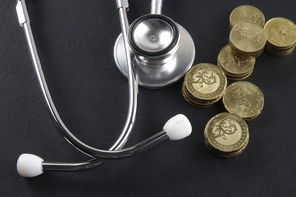 Červená stetoskop, mince a puzzle na černém pozadí. Lékařská koncepce. — Stock fotografie