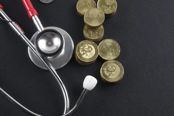 Red stethoscope,coin and puzzle on black. Medical concept. — Stock Photo, Image