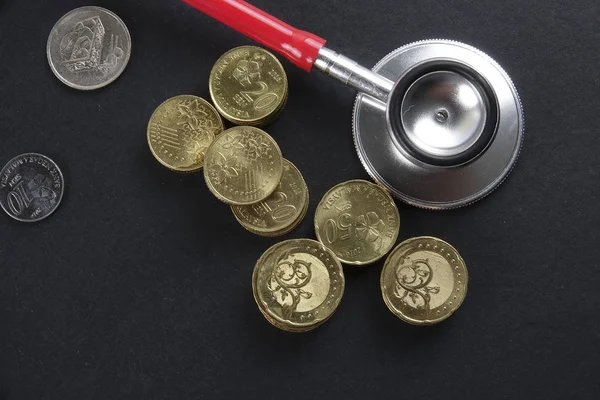 Red stethoscope,coin and puzzle on black. Medical concept. — Stock Photo, Image