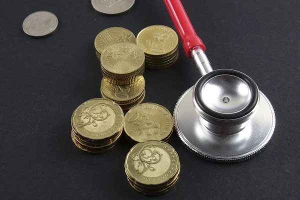 Red stethoscope,coin and puzzle on black. Medical concept. — Stock Photo, Image