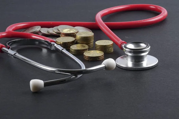 Red stethoscope,coin and puzzle on black. Medical concept. — Stock Photo, Image