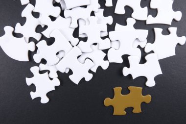 Siyah arka plan üzerine beyaz bulmaca içinde altın bulmaca öne.