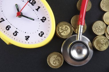 Kırmızı stetoskop ve siyah arka plan üzerinde paralar. Tıbbi