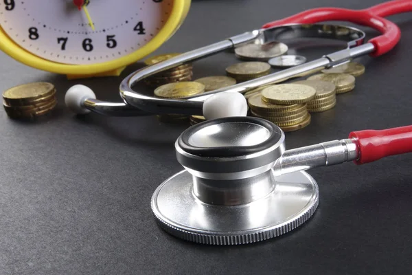 Red stethoscope and coins on black background. Medical — Stock Photo, Image