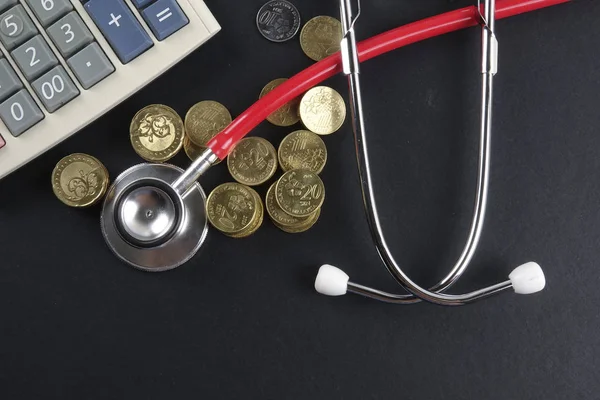 Red stethoscope and coins on black background. Medical — Stock Photo, Image