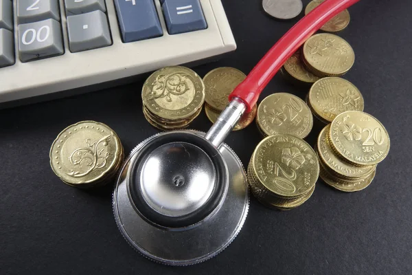 Red stethoscope and coins on black background. Medical — Stock Photo, Image